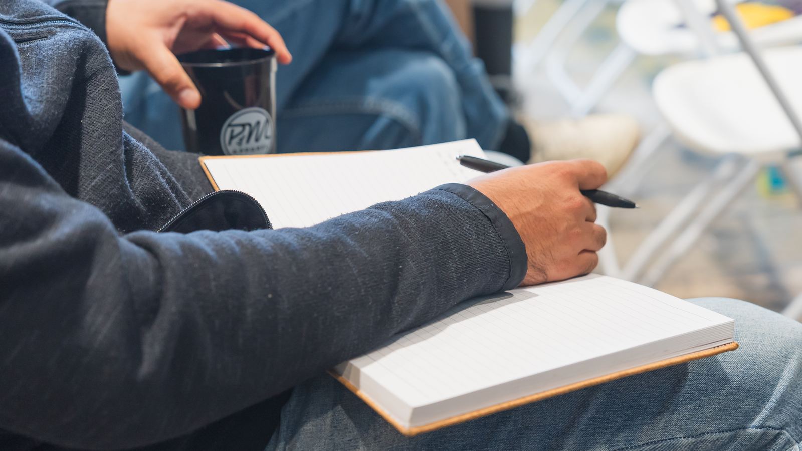 An attendee taking notes during a Flyover Con session
