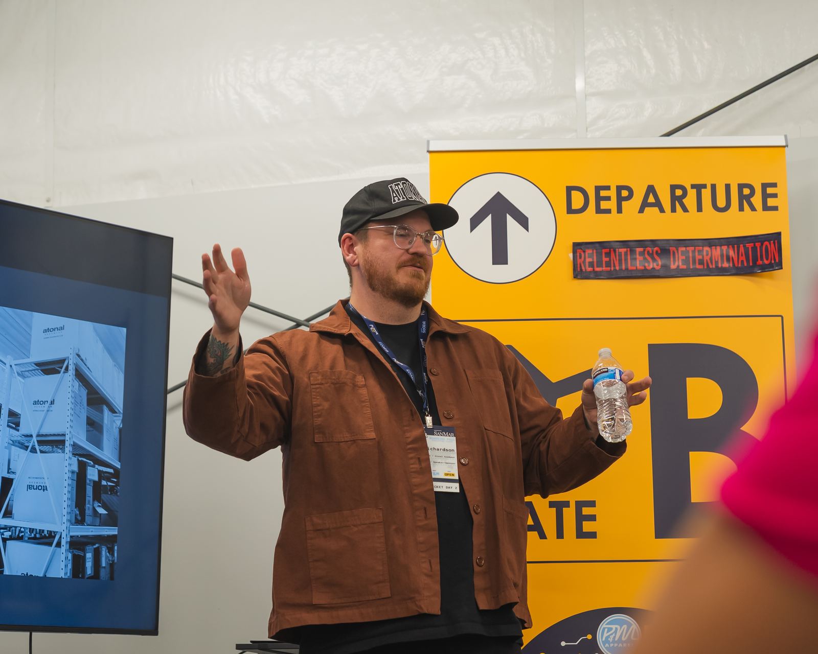 A speaker presenting near the Gate B sign at Flyover Con